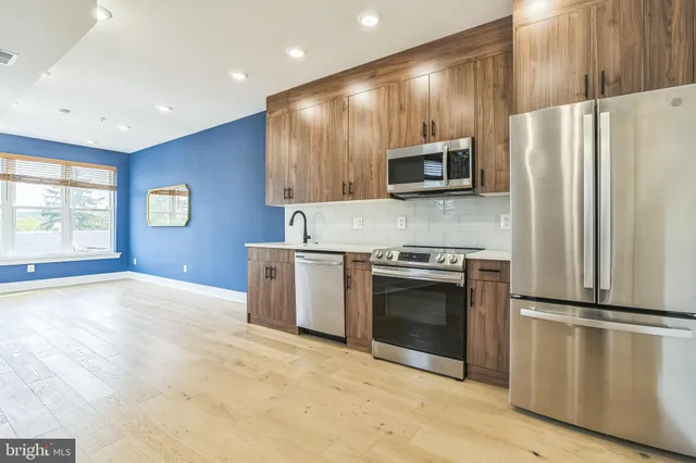 a kitchen with granite countertop a refrigerator and a stove top oven