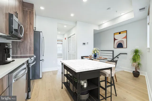 a open kitchen with stainless steel appliances granite countertop a stove refrigerator sink and microwave