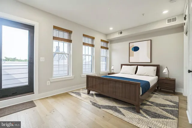 a spacious bedroom with a bed and glass window