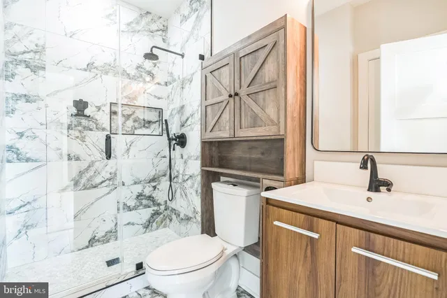 a bathroom with a sink toilet vanity and shower