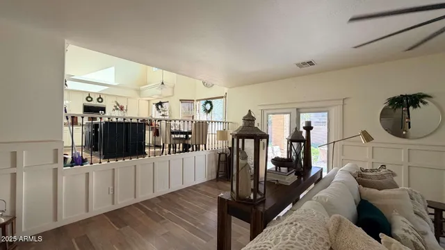 a living room with furniture a flat screen tv and a floor to ceiling window