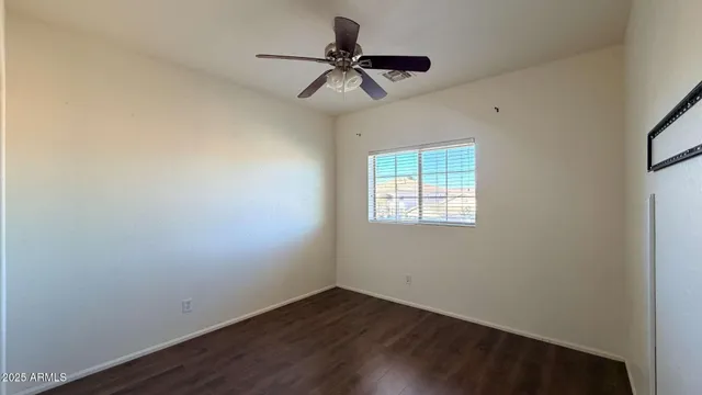 a view of room with a ceiling fan and wooden floor