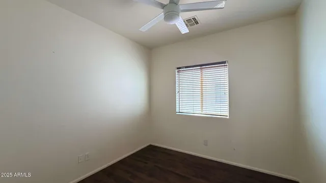 an empty room with a window and wooden floor
