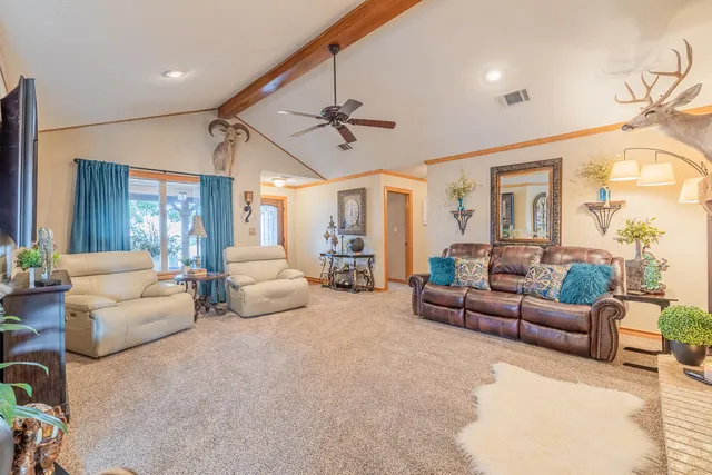a living room with furniture and a dining table with wooden floor