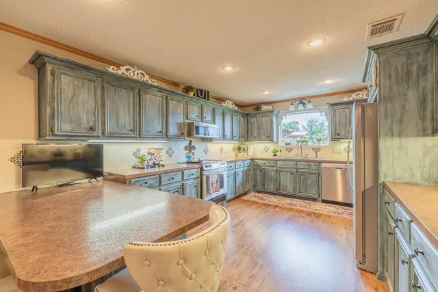 a kitchen with stainless steel appliances granite countertop a refrigerator and a sink