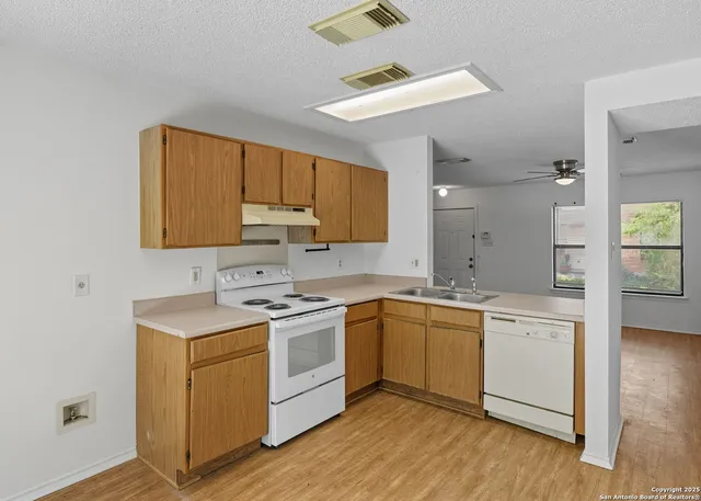 a kitchen with a sink cabinets and wooden floor