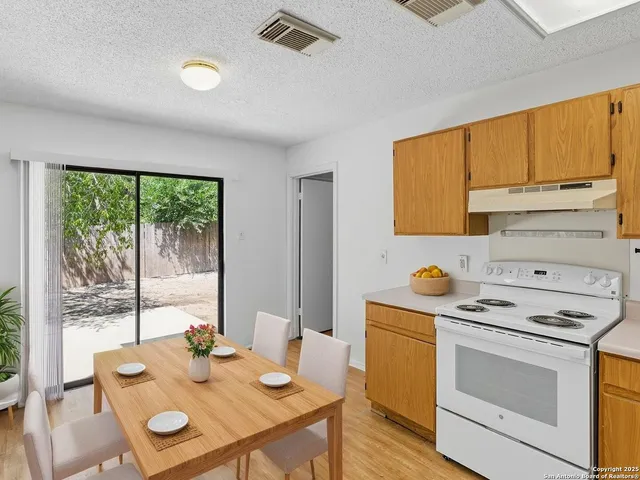 a kitchen that has a stove a table and chairs in it