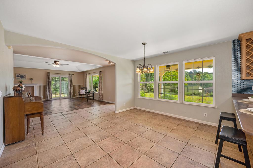 6181 Lambert Lane El Dorado, CA 95623 - Photo 28 of 68 unfurnished dining area featuring ceiling fan, arched walkways, light tile patterned floors, and suspended lighting
