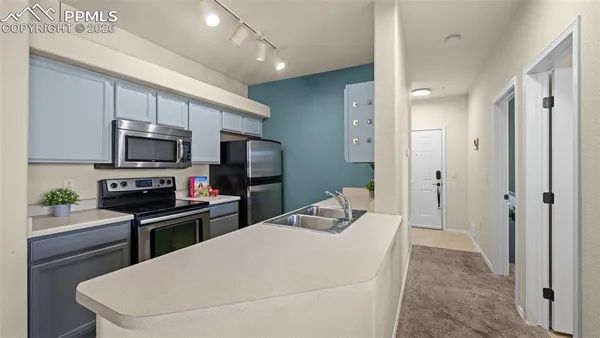 a kitchen with stainless steel appliances a stove microwave and refrigerator