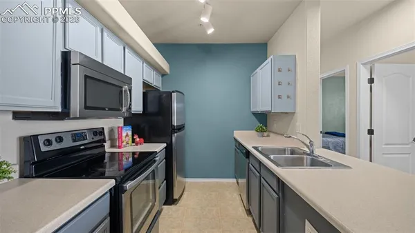 a kitchen with stainless steel appliances a stove microwave and sink