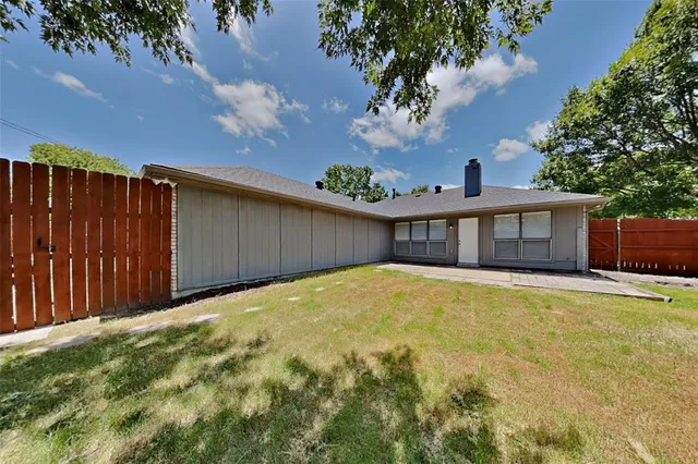 a view of a house with backyard and a tree
