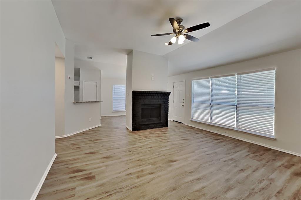 7809 Meadowlark Lane Rowlett, TX 75088 - Photo 3 of 18 an empty room with wooden floor fan and windows