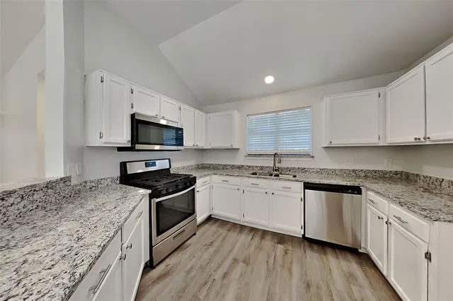 a kitchen with granite countertop a sink and steel appliances