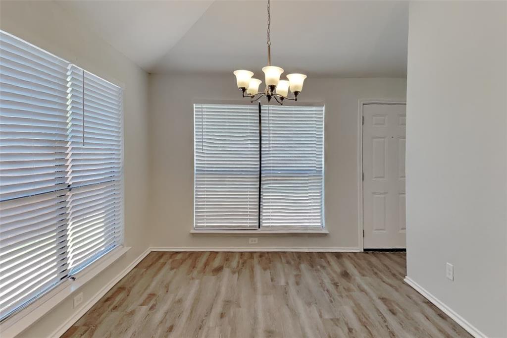 7809 Meadowlark Lane Rowlett, TX 75088 - Photo 7 of 18 a view of an empty room with wooden floor and a window