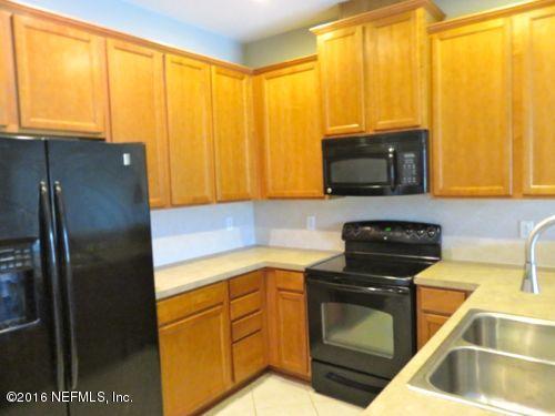 12958 Spring Rain Road Jacksonville, FL 32258 - Photo 2 of 18 a kitchen with a sink a stove and a microwave
