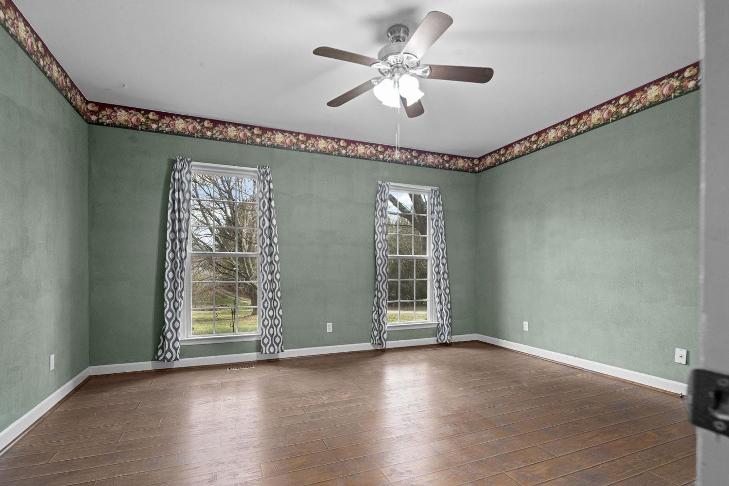 2109 Howson Road Raleigh, NC 27603 - Photo 16 of 36 an empty room with wooden floor fan and windows