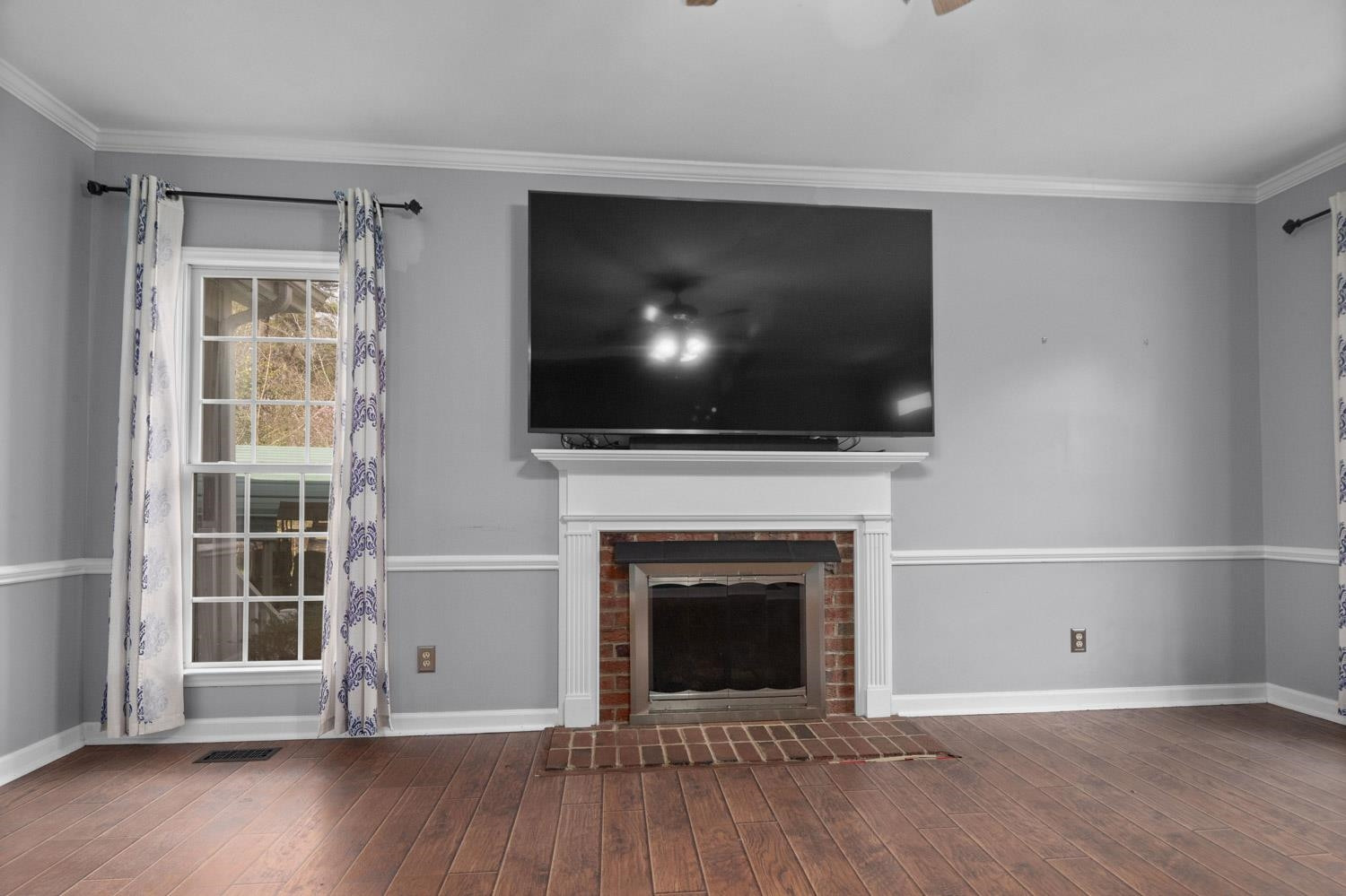 2109 Howson Road Raleigh, NC 27603 - Photo 10 of 36 a view of an empty room with wooden floor and a fireplace