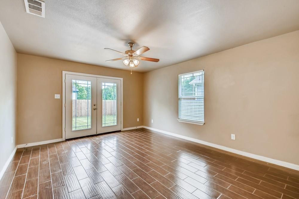 713 Rike Street McKinney, TX 75069 - Photo 11 of 29 a view of an empty room with a window and wooden floor