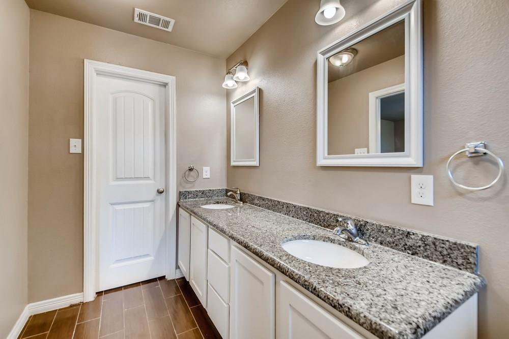 713 Rike Street McKinney, TX 75069 - Photo 13 of 29 a bathroom with a granite countertop double vanity sink and a mirror