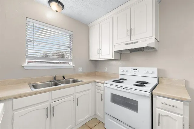 a kitchen with white cabinets and white appliances