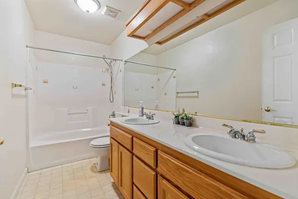 an empty room with a ceiling fan and carpet