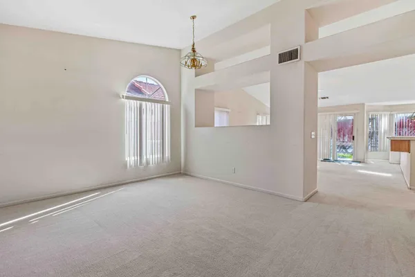 en empty room with windows and ceiling fan