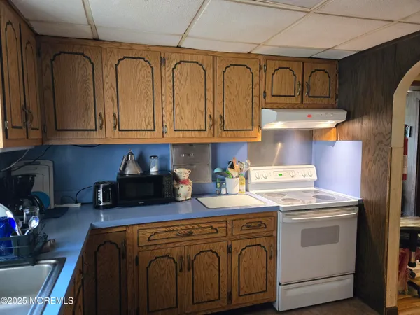 a kitchen with stainless steel appliances granite countertop a sink a stove a refrigerator and cabinets