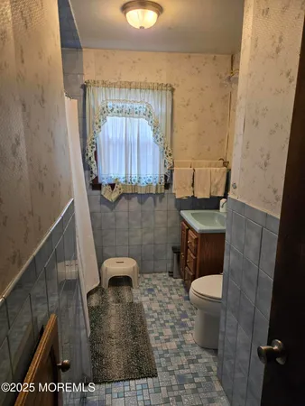a bathroom with a toilet a sink and a mirror