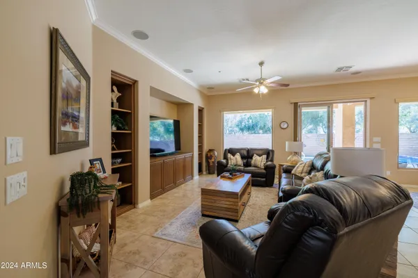 a living room with furniture a large window and a flat screen tv