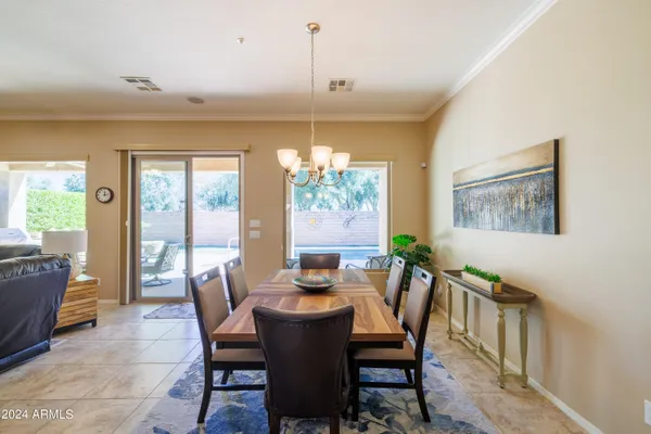 a dining room with furniture a chandelier and wooden floor