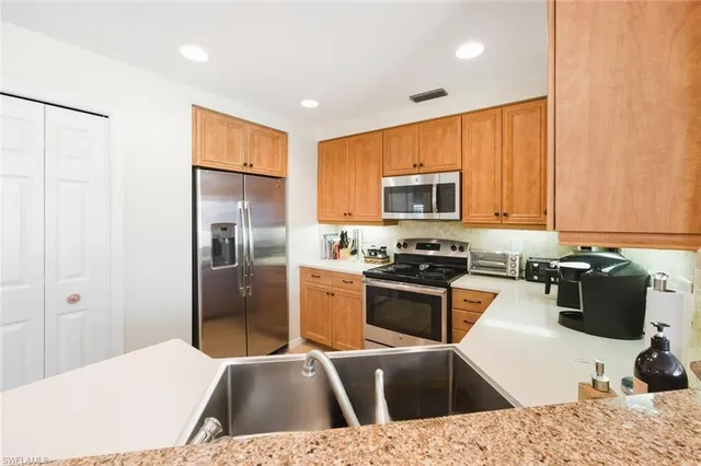 a kitchen with a refrigerator a stove a microwave a sink and cabinets