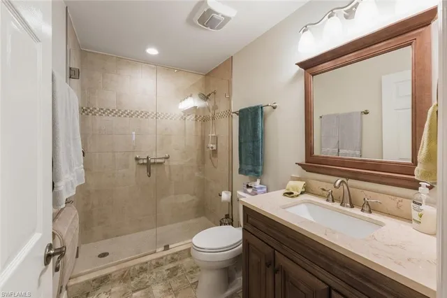 a bathroom with a granite countertop sink toilet and shower