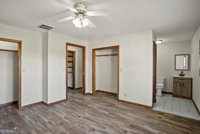 a view of a room with wooden floor and a ceiling fan