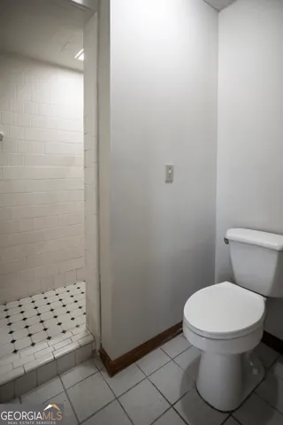 a white toilet sitting next to a shower