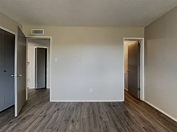 an empty room with wooden floor and closet