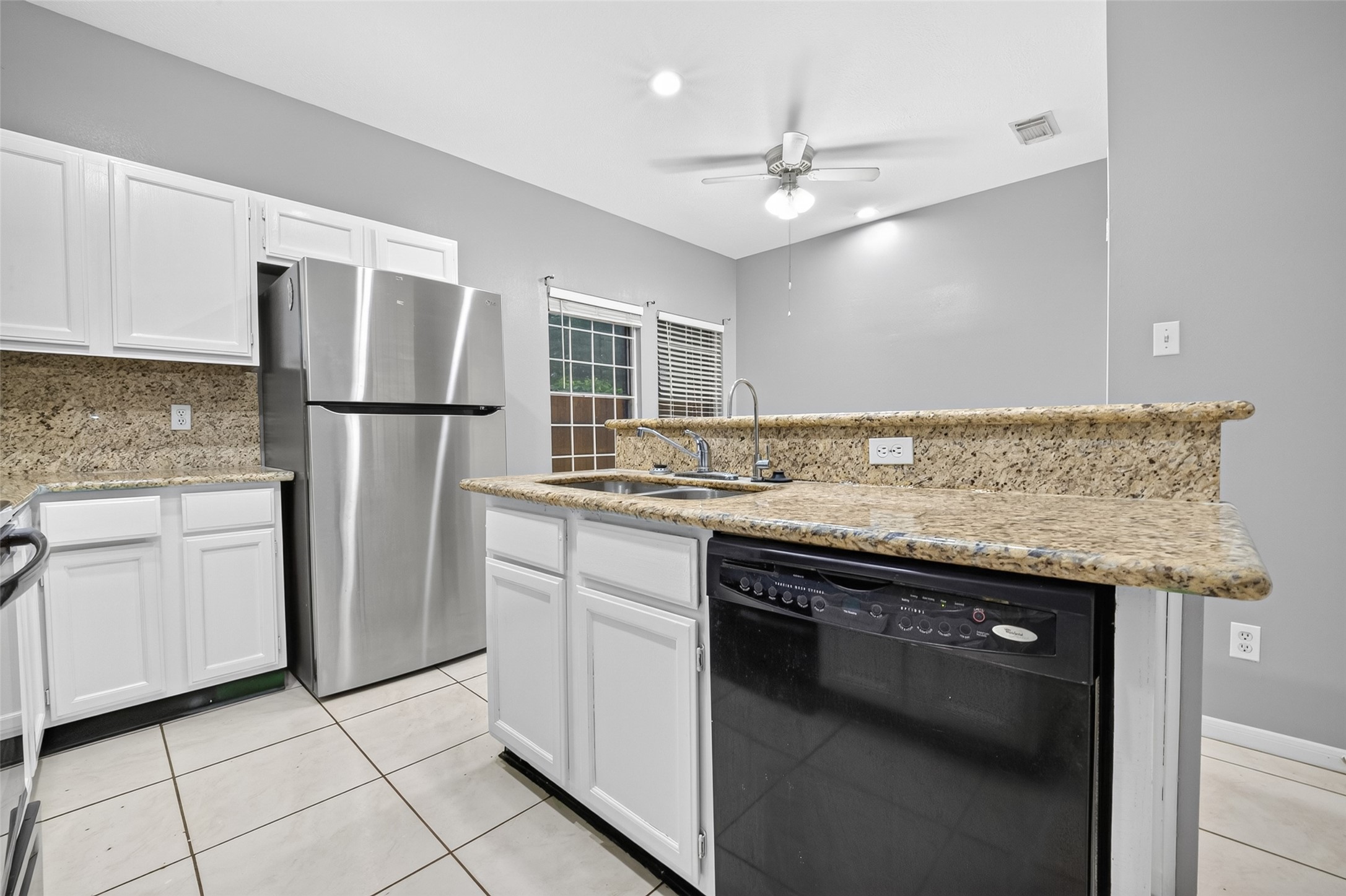 13607 Sable Lane Houston, TX 77014 - Photo 16 of 46 a kitchen with kitchen island granite countertop a sink cabinets and stainless steel appliances