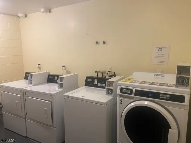 a view of washer and dryer with bathroom in the background