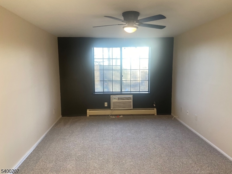 5 Terrace Drive Chatham, NJ 07928 - Photo 4 of 13 an empty room with chandelier fan and windows