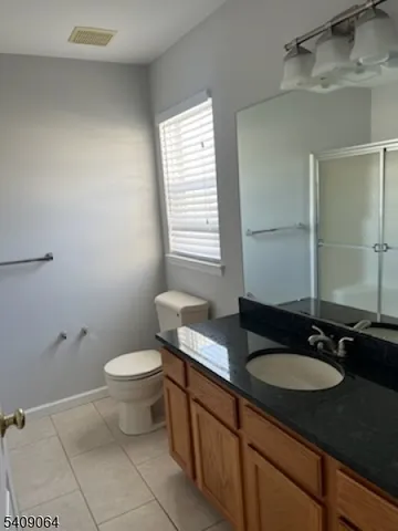 a bathroom with a granite countertop sink toilet and mirror