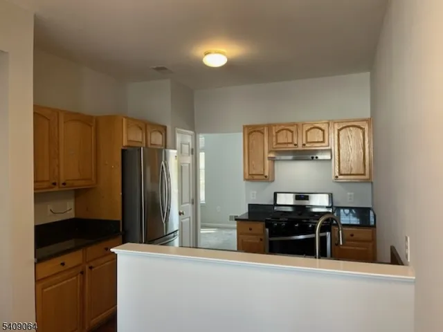 a kitchen with stainless steel appliances a refrigerator and stove