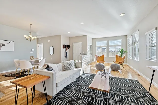 a living room with furniture dining table and a chandelier