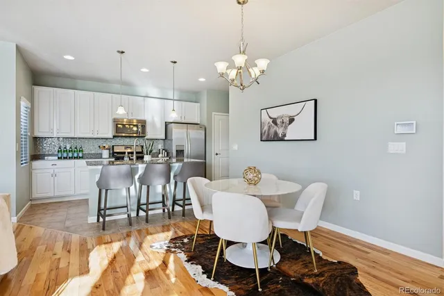 a view of a dining room with furniture a chandelier and wooden floor