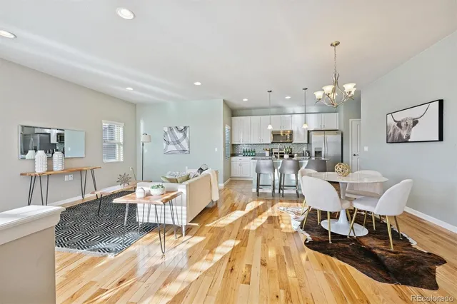 a view of a dining room with furniture a kitchen and chandelier