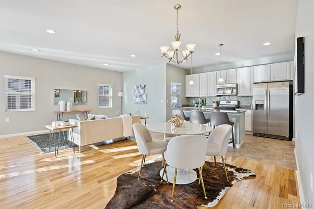 a view of a dining room with furniture a chandelier and wooden floor
