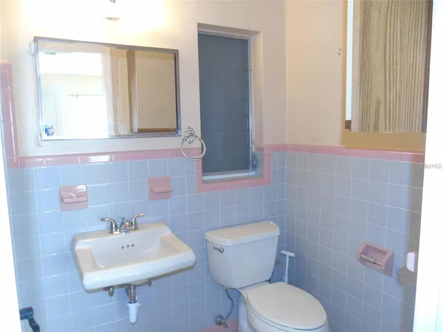 a bathroom with a sink a toilet and mirror