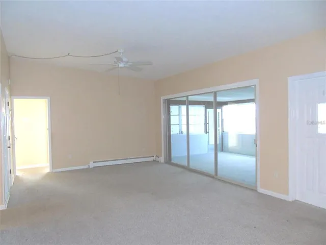 an empty room with chandelier fan