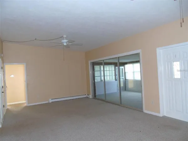 an empty room with chandelier fan