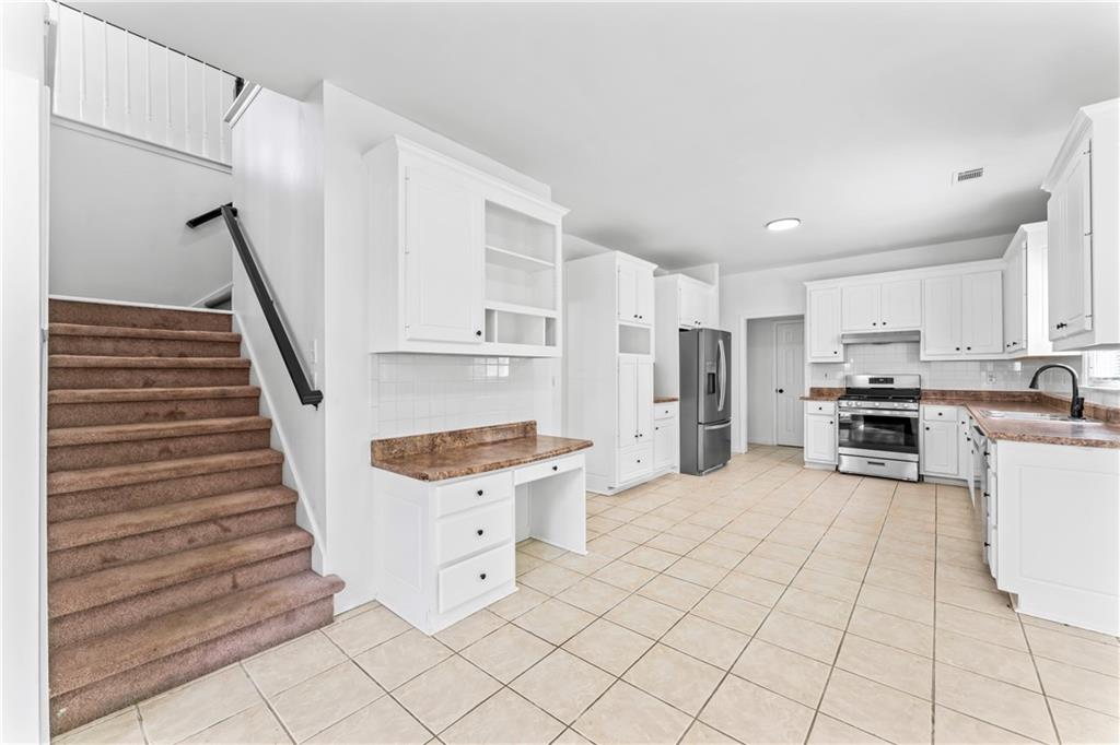 4267 Azalea Walk Ellenwood, GA 30294 - Photo 11 of 24 a kitchen with stainless steel appliances kitchen island granite countertop a refrigerator and a stove top oven