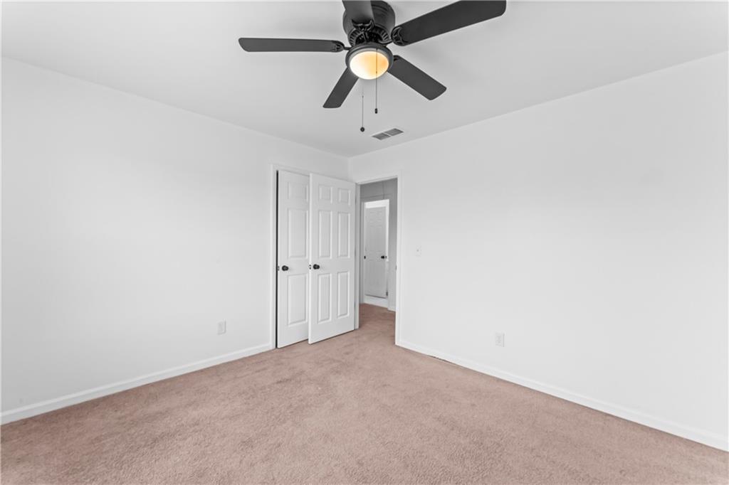 4267 Azalea Walk Ellenwood, GA 30294 - Photo 15 of 24 an empty room with closet and a chandelier fan