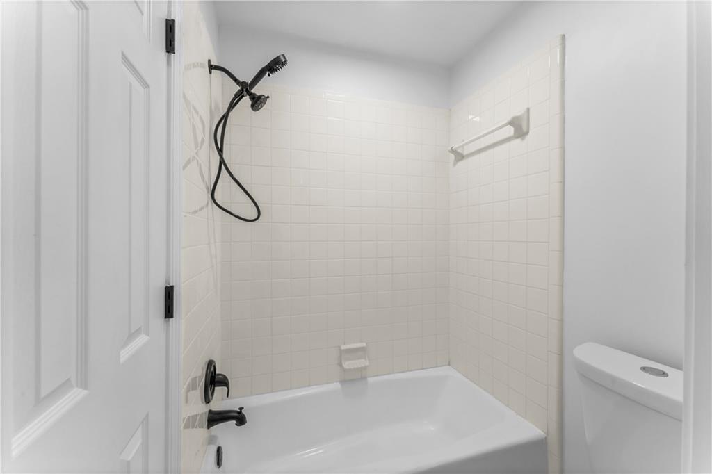 4267 Azalea Walk Ellenwood, GA 30294 - Photo 17 of 24 a bathroom with a white bath tub with a shower